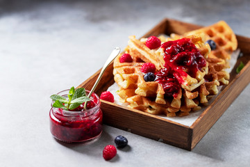 Homemade sourdough waffles with berry sauce for breakfast. The concept of proper nutrition. Selective focus, copy space. - obrazy, fototapety, plakaty