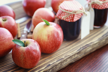 Fresh apples on a wooden board. Harvest of red apples. Fruits and cinnamon on the table.