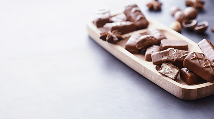 Chocolate bars on a black background in backlight. Chocolate with filling. Sweet sweets for snack and tea.