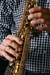 Obraz premium soprano saxophone in hands on a black background