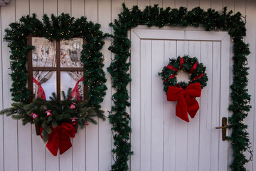Fototapeta na wymiar Door and window of a fake white house beautifully decorated for christmas