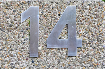 A house number plaque, showing the number fourteen (14)