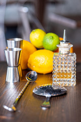 Set of a bartender accessories with little bottles of essenceand fruits on a dark wooden table