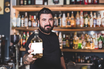 Hipster bartender offers to drink a soft drink, mock up on the label of the bottle. Concept of invitation to drink alcohol