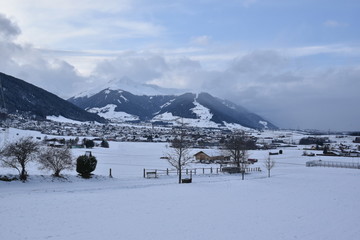 View of a village in winter with snow and mountains