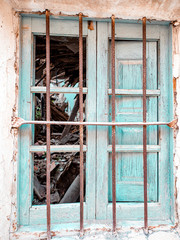 Broken window of an abandoned house in a village in Spain.