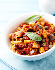 Pasta with vegetable sauce and fresh herbst. Bright background.