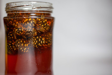 Jar of spruce jam. Jam from pine cones. Glass jar with sweetness. Treat on a white background.