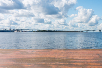 Template. Photo of an empty surface on a background of water and sky with clouds.