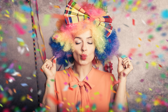 Englisch  beautiful young woman with colorful afro wig and colorful carnival make-up and confetti