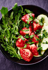 Healthy and tasty salad with tomatoes, cucumber, chive and rocket. Top view. 