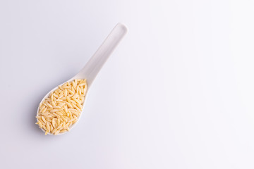 Orzo pasta, isolated on white background. Italian orzo pasta shaped like grains of rice, copy space, soft light