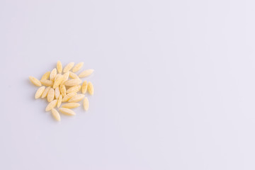 Obraz premium Orzo pasta, isolated on white background. Italian orzo pasta shaped like grains of rice, copy space, soft light