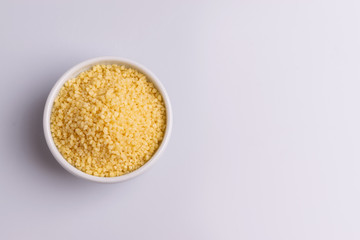Dry couscous isolated on white background, soft light, copy space.