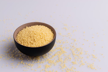 Dry couscous isolated on white background, soft light, copy space.