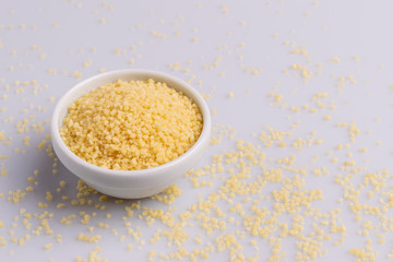 Dry couscous isolated on white background, soft light, copy space.