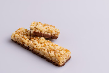 Muesli granola bar with milk chocolate on white background, soft light, copy space