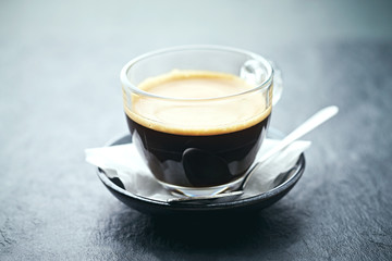 Coffee in glass cup on stone background. Close up. 