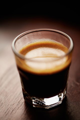 Coffee in glass cup on dark background. Close up. 