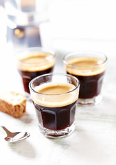 Three glasses of coffee on bright wooden background. 