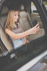 Cute teenage girl listening to her favorite music/audiobook on hig-end headphones during a roadtrip