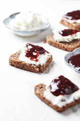Fototapeta na wymiar Sandwiches with cream cheese and jam. Whitre wooden background. 