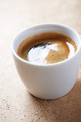 Cup of coffee on bright stone  background. Close up.