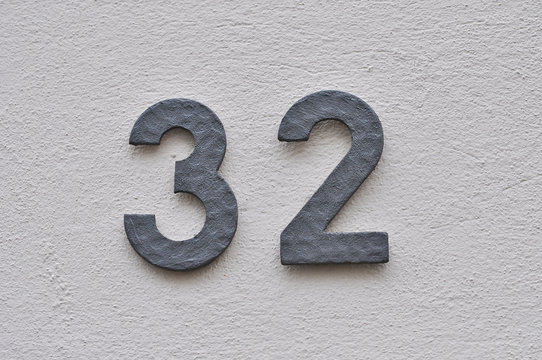 A house number plaque, showing the number thirty two (32)