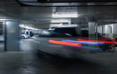 Underground parking. Cars parked in a garage with no people. Many cars in parking garage interior. Underground parking with cars (color toned image)