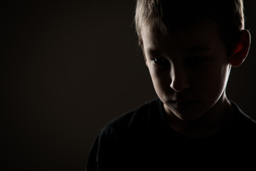 Fototapeta na wymiar Grief-stricken little boy - feeling intense sorrow, remorse, sadnesss - studio portrait - vivid emotions series