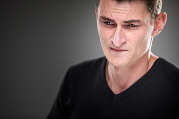 Obraz premium Fear/anxiety/regret/uncertainty in a young man - effects of a difficult life situation - vivid emotions concept