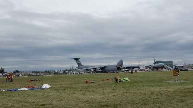 Left To Right Pan Of Grass With Aircraft In Background During Airshow