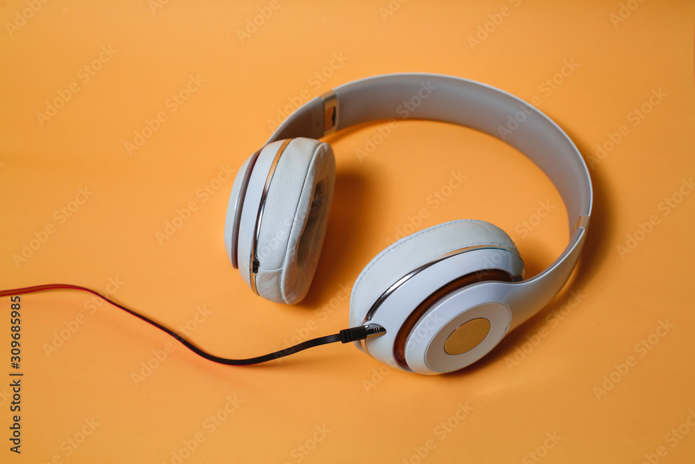 Wall mural white audio headphones, isolated on lush lava background.