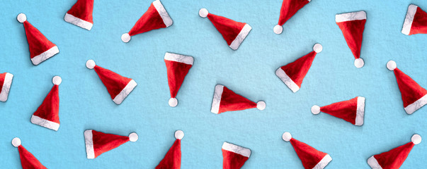 Pattern made of Santa Claus's hat on blue background. Minimal concept, panoramic image