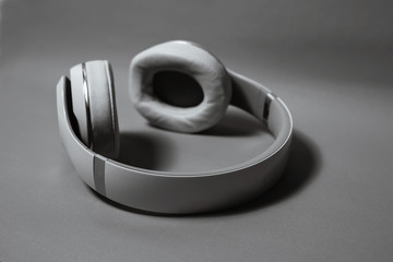 Wireless audio headphones, isolated on gray background. Black and white photo.