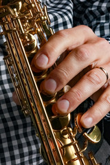 Fototapeta premium soprano saxophone in hands on a black background