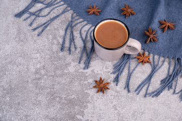 Obraz na płótnie Canvas Coffee with star anise on a blue scarf and on a grey structured background