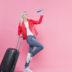 Cheerful young woman tourist hurries to the airport with her Luggage.