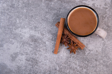 Fototapeta na wymiar Cafe with cinnamon and star anise on a grey structured background