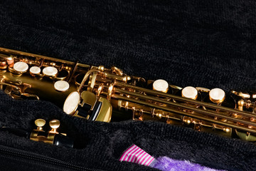 soprano saxophone in a case on a black background