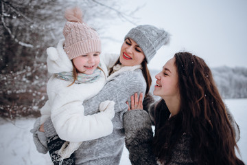 happy family mother and child daughter having fun, playing at winter walk outdoors