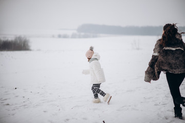 happy family sisters child daughter having fun, playing at winter walk outdoors
