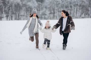 Fototapeta na wymiar happy family mother and child daughter having fun, playing at winter walk outdoors