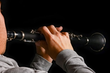 clarinet in the hands of a man on a black background