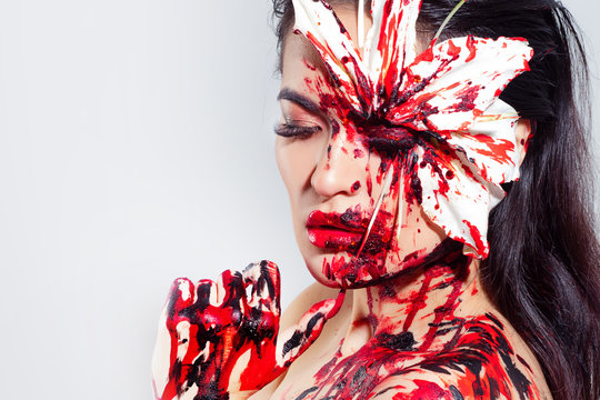 Blood Lily, scary and sexy Halloween look. Beautiful young brunette girl on white background