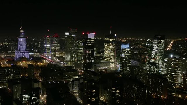 Aerial view of the night city with skyscrapers and busy streets with traffic jams during rush hour. Warsaw, Poland. 13. December. 2019. Drone shot at night metropolis with skyscrapers and buildings.