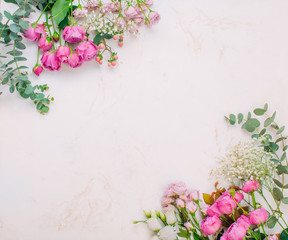 Frame of flowers on white marble background with copy space