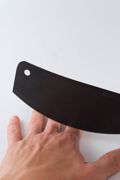 A man holding black machete against white background, and cut off his finger