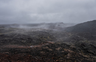 Leirhnjukur old black lava field and smoke in Iceland, overcast. Cloudy day in September 2019