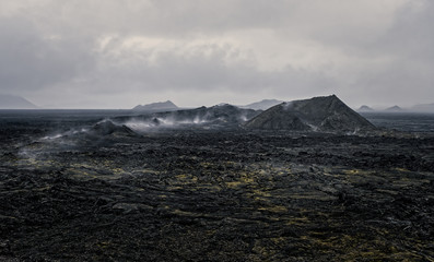 Leirhnjukur old black lava field and smoke in Iceland, overcast. Cloudy day in September 2019